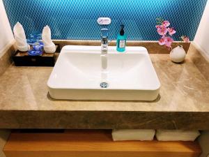 - un lavabo blanc avec une bouteille de savon sur un comptoir dans l'établissement Holiday Inn Express Liaocheng Chiping, an IHG Hotel, à Liaocheng