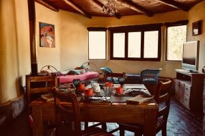 a dining room with a table and chairs and a bed at misky wayra in Capilla del Monte