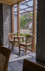 een terras met twee stoelen, een tafel en een raam bij Le Boutique Danang in Da Nang