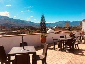 a patio with tables and chairs on a roof at 61Prado Hotel in Medellín