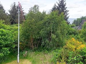 a pole in the middle of a field with trees at 5 person holiday home in Roslev in Roslev