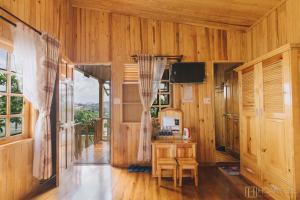 Habitación con paredes de madera, mesa y sillas. en Danh Tien Villa, en Da Lat