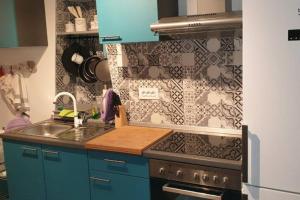 a kitchen with a stove and a sink and a wall at Apartman Opal in Cunski