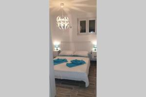 a bedroom with a bed and a chandelier at Apartman Opal in Čunski