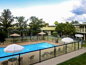 a swimming pool with two umbrellas at OYO Hotel Brownwood Hwy 67 in Brownwood