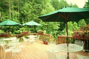 a wooden deck with tables and chairs and umbrellas at Stay Berkshires in Williamstown