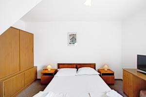 1 Schlafzimmer mit 2 Betten und einem Flachbild-TV in der Unterkunft Villa Supetar in Supetar