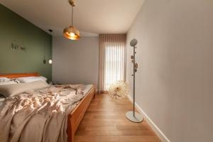 a bedroom with a large bed and a floor fan at Beach Apartments in Haifa