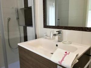 a bathroom with a white sink and a shower at Bougainvillea Relais in Sorrento