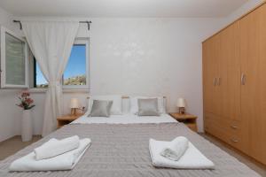 a bedroom with a large bed with two towels on it at Apartments Villa Carica B&B in Mimice