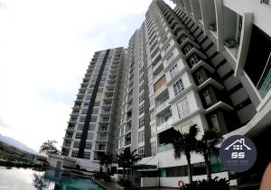 a large apartment building with a pool in front of it at KULAI HOME STAY @IOI MALL/JPO/AEON/SENAI AIRPORT in Kulai