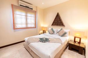 Un dormitorio con una gran cama blanca y una ventana en Villa Tanamera, en Bangrak Beach