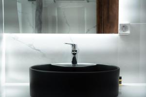 a black sink with a faucet in a bathroom at Alexandros by the Beach - Serifos in Livadakia
