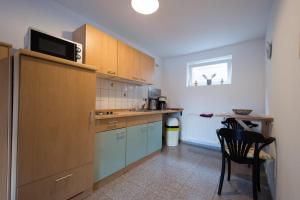 a kitchen with wooden cabinets and a table and a chair at Entspanntes wohnen in Ostseenähe, gute Anbindung in Ratekau