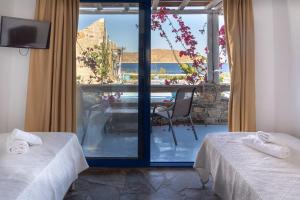 a room with two beds and a view of the ocean at Alexandros by the Beach - Serifos in Livadakia