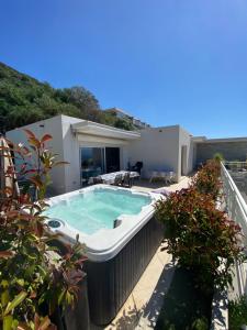 a hot tub on the balcony of a house at VIzzavona piscine et jacuzzi in Ajaccio