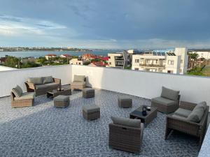 a patio with couches and chairs on a balcony at Pensiunea Mara in Techirghiol