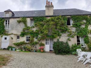 a house with ivy on the side of it at Maison Normande in Asnelles