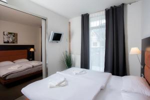 Habitación de hotel con 2 camas y ventana en Apartments Trio, en Kranjska Gora