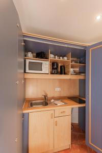 a small kitchen with a sink and a microwave at Ferienwohnung Hummelhus Elmenhorst in Elmenhorst
