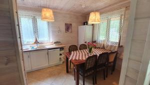 a kitchen with a table and chairs and a refrigerator at Domek na Szumach in Susiec