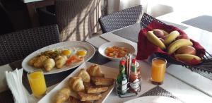Eco Park Lodge في سنتوريون: طاولة مع صحن من طعام الإفطار وعصير البرتقال
