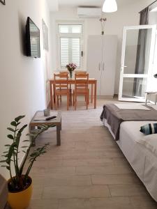 a bedroom with a bed and a table and chairs at Apartments Ružica in Zaostrog