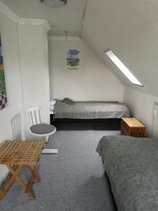 Zimmer mit 2 Betten, einem Tisch und einem Stuhl in der Unterkunft Værelse som dobbelt el. enkelt, Engen 5, 7770 Vestervig in Vestervig