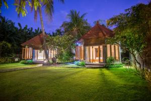 a house with a lawn in front of it at Mojito Beach Villas in Kubutambahan