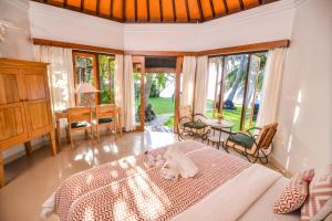 a bedroom with a bed with a cat laying on it at Mojito Beach Villas in Kubutambahan