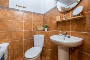 a bathroom with a toilet and a sink and a mirror at Casa Randonneur, traditional townhouse in Álora. in Alora +25 photos