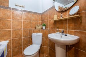 a bathroom with a toilet and a sink and a mirror at Casa Randonneur, traditional townhouse in Álora. in Alora