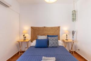 una camera con un letto blu e due tavolini di Casa Randonneur, traditional townhouse in Álora. ad Alora