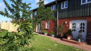 a brick house with potted plants in front of it at " Haus zwischen den Meeren " in Strübbel