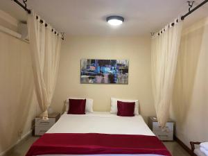 a bedroom with a large white bed with red pillows at Residence Maeva in Mamoudzou