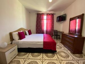 a bedroom with a bed and a dresser and a television at Residence Maeva in Mamoudzou