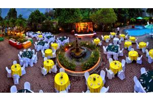 a group of tables and yellow umbrellas and a fountain at Hotel Fleuris in Puerto Princesa City