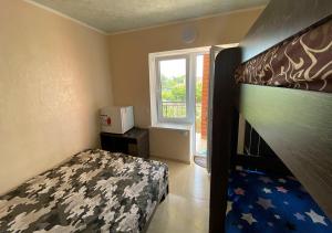 a small bedroom with a bed and a window at Катюша морская in Zatoka