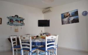 una sala da pranzo con un tavolo e quattro sedie di Villa con piscina - Pt54 a Torre dell'Orso