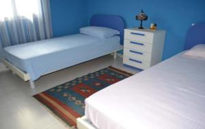 una camera blu con due letti, un comò e una gonna da letto di Villa con piscina - Pt54 a Torre dell'Orso