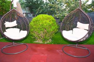 two hanging chairs with white pillows in a yard at Delta Est Hotel & Restaurant in Sulina +27 photos