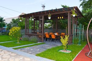 a gazebo with a table and chairs in a garden at Delta Est Hotel & Restaurant in Sulina