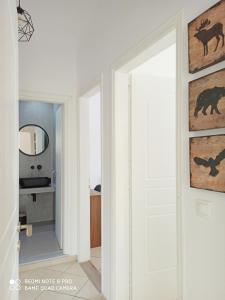 um corredor com uma porta branca e um espelho em Bourbos Summer Rooms em Himare