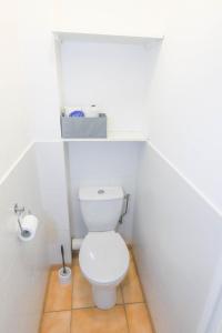 a white bathroom with a toilet with a shelf above it at Orangeraie du Cap d'Antibes in Antibes