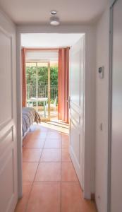 a hallway with a door open to a room with a bed at Orangeraie du Cap d'Antibes in Antibes