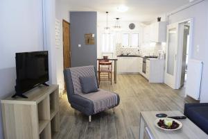ein Wohnzimmer mit einem Flachbild-TV und eine Küche in der Unterkunft Athens city Poppy's Dreamy Apartment, Thissio in Athen