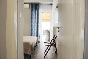 una camera con un letto e una sedia e una finestra di Athens city Poppy's Dreamy Apartment, Thissio ad Atene
