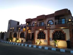 un edificio con luces en el lateral de una calle en TheCastle Hotel en Dahab