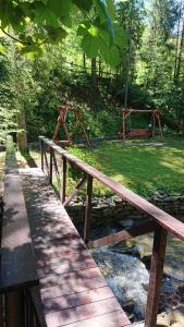 a wooden bridge over a stream in a park at Domek Krasnal in Juszczyn