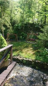 a wooden bridge over a stream in a forest at Domek Krasnal in Juszczyn